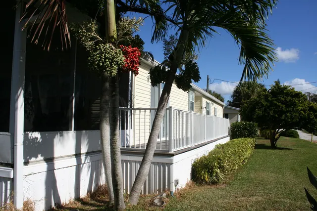 a view of a lake with a bench under large trees