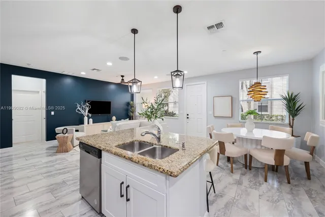 a kitchen with a table a sink and living room view