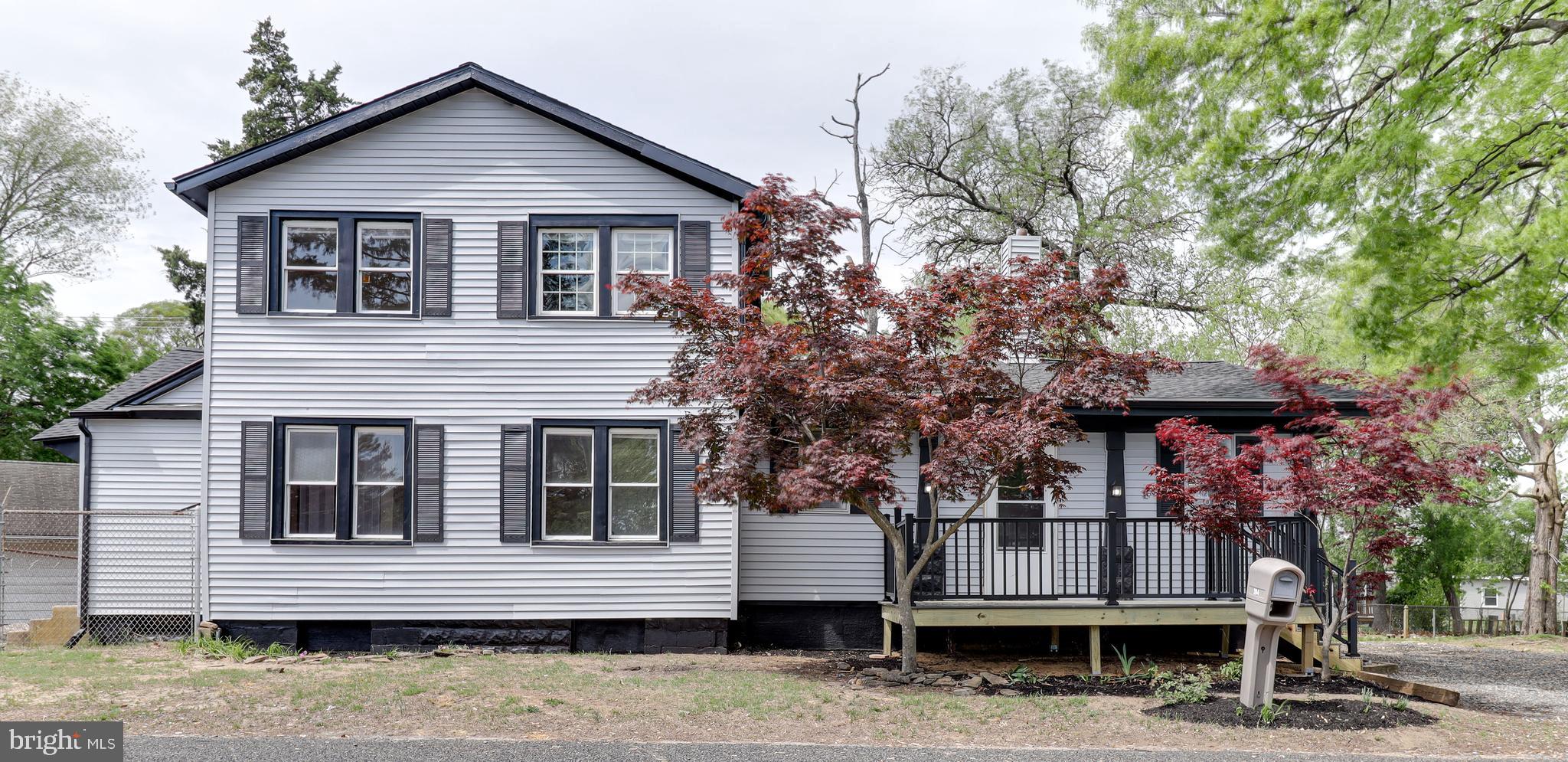 a front view of a house with a tree