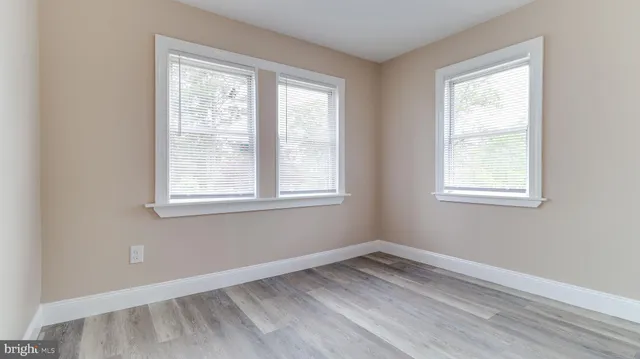 a view of a room with wooden floor and windows