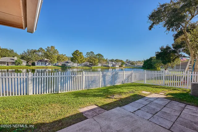 a view of a yard with swimming pool and wooden fence