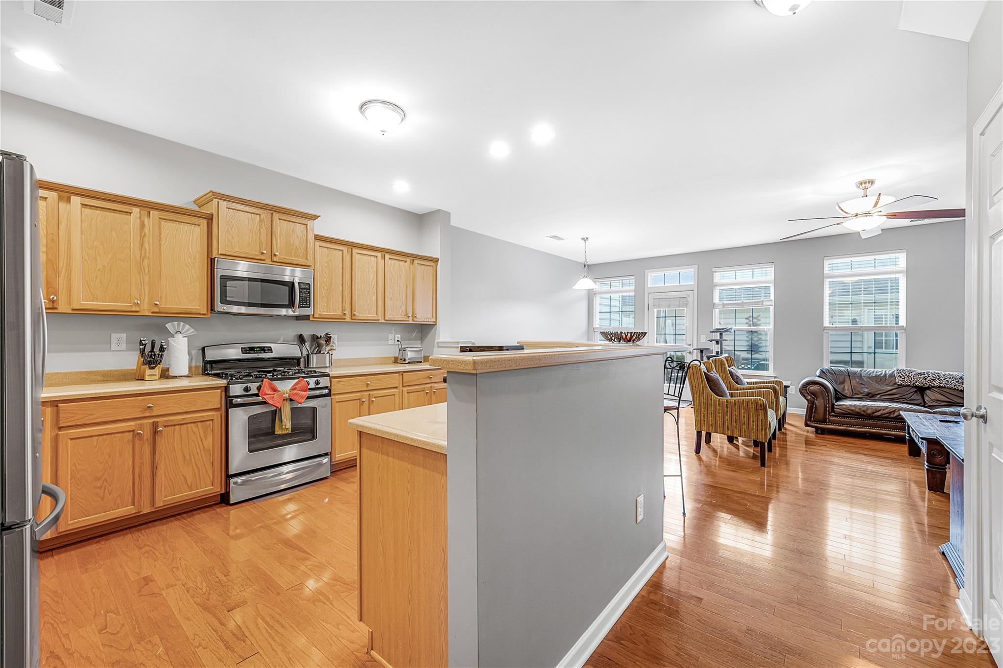 8307 Viewpoint Lane Cornelius, NC 28031 - Photo 4 of 25 a kitchen with stainless steel appliances granite countertop a stove top oven a sink a dining table and chairs with the wooden floor