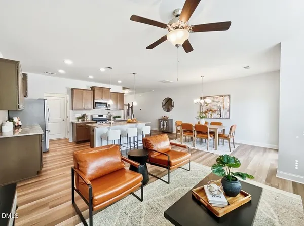 a living room with furniture kitchen view and a window
