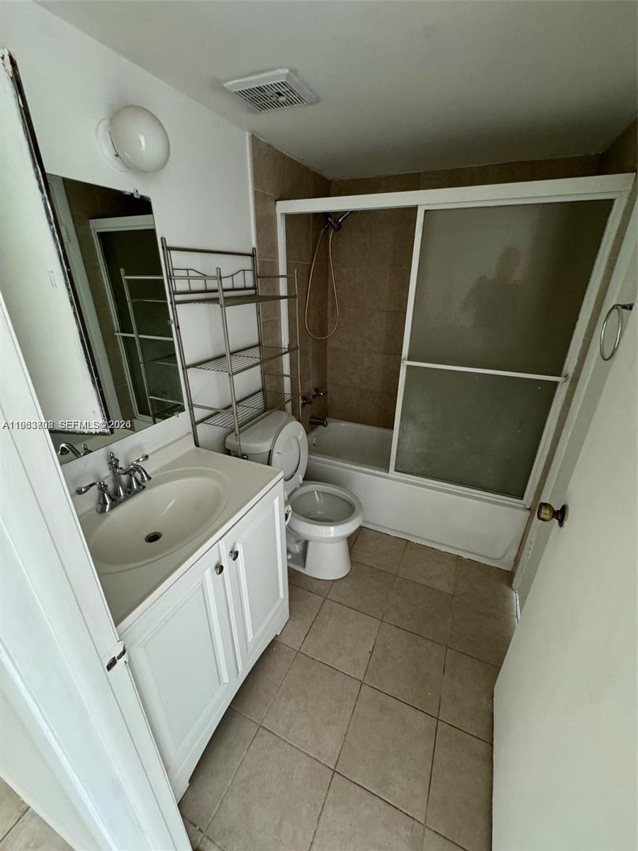 11790 Southwest 18th Street, Unit 3043 Miami, FL 33175 - Photo 9 of 12 a bathroom with a sink a toilet a mirror and shower