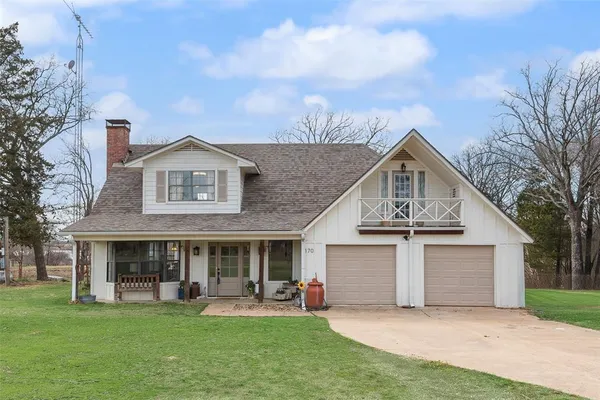 a front view of a house with a garden and yard
