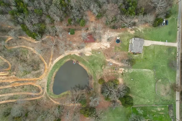 a view of a house with a big yard and large trees