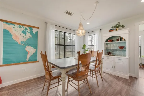 a kitchen with stainless steel appliances a sink a stove a refrigerator with white cabinets and wooden floor