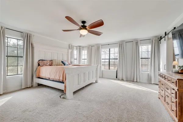 a bedroom with a bed window and a flat screen tv