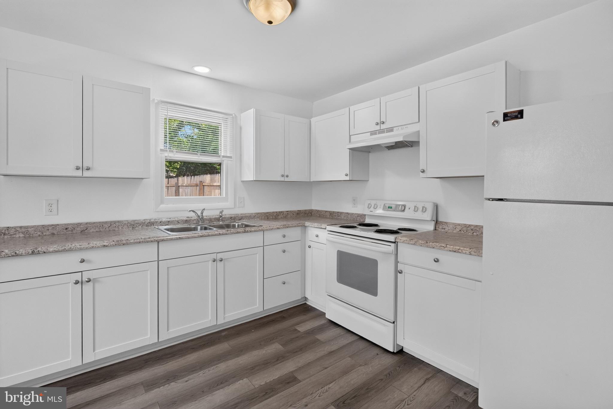 351 Calvert Street Chestertown, MD 21620 - Photo 8 of 19 a kitchen with granite countertop white cabinets and white appliances