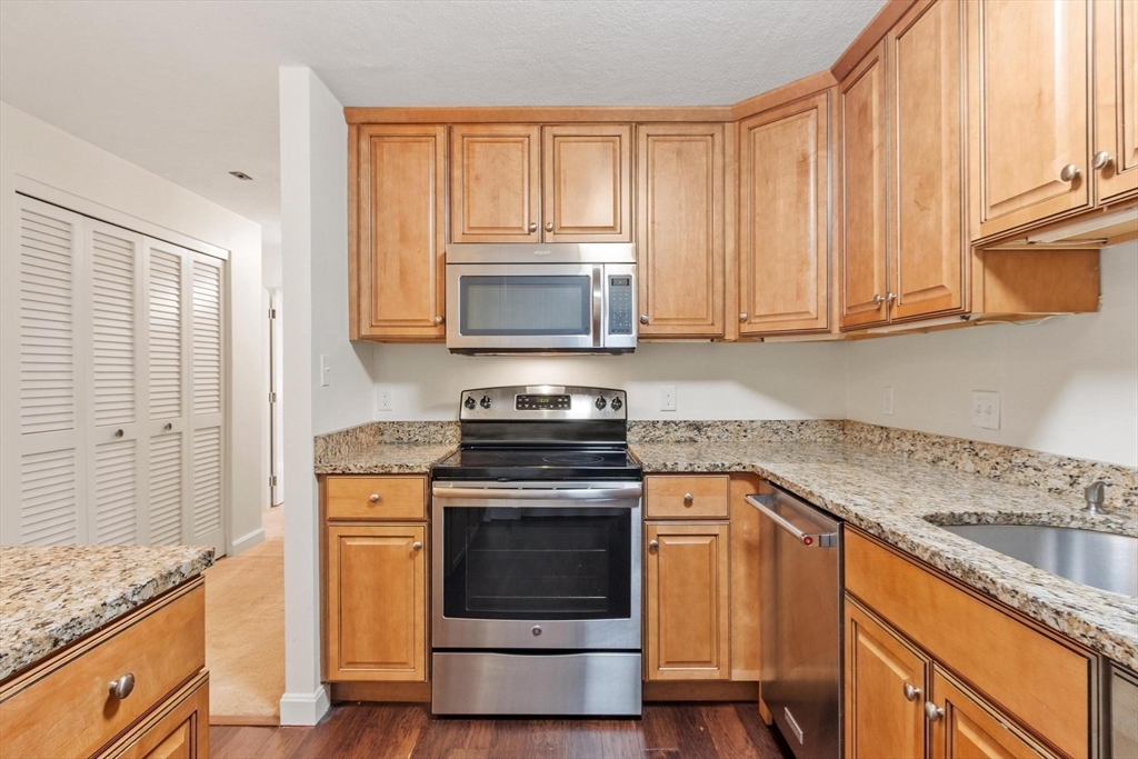 420 Great Road, Unit C1 Acton, MA 01720 - Photo 23 of 29 a kitchen with granite countertop cabinets stainless steel appliances and a window