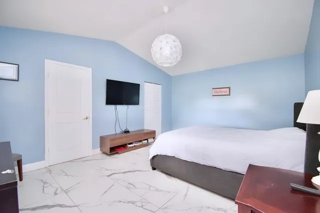 a bedroom with a bed and a flat screen tv