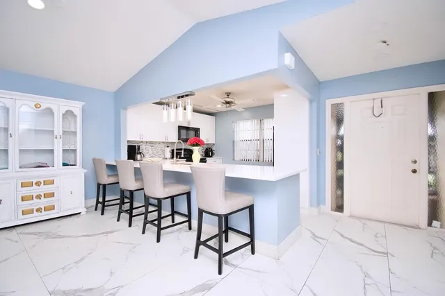 a living room with furniture and kitchen area