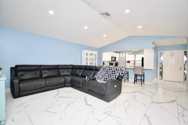 a living room with furniture and kitchen