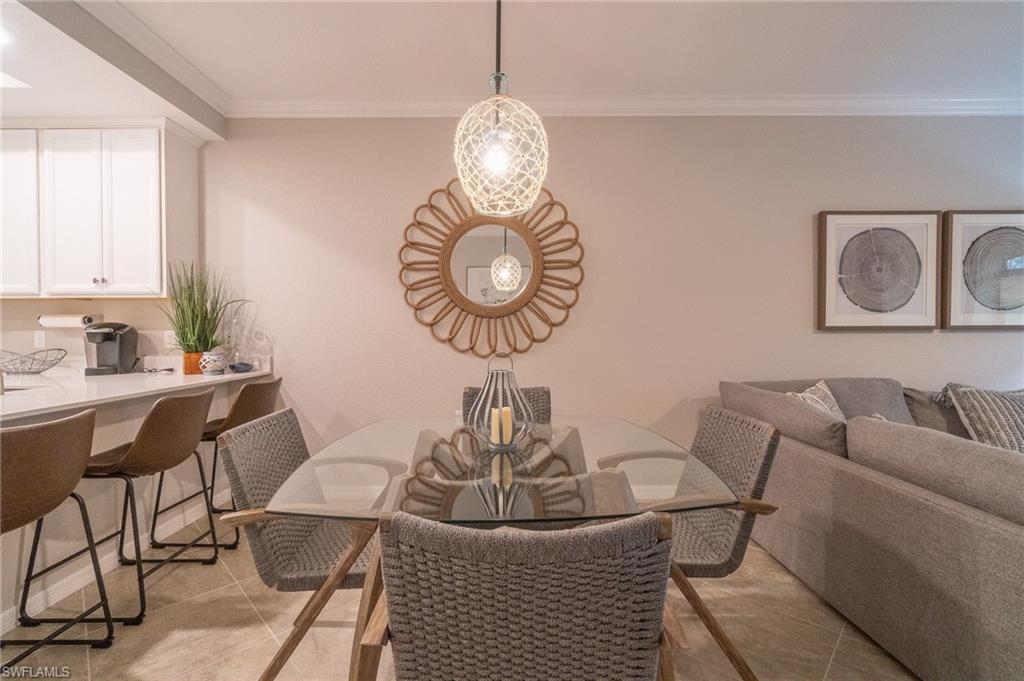 9596 Trevi Court, Unit 5414 Naples, FL 34113 - Photo 10 of 34 a dining room with furniture a rug and a window