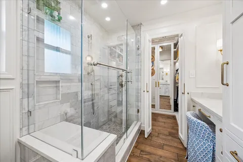 a bathroom with a glass shower door and a glass door