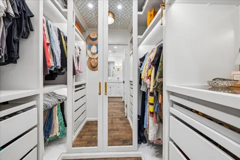 a view of walk in closet with clothes and shoes