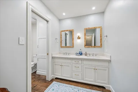 a spacious bathroom with a double vanity sink mirror and toilet