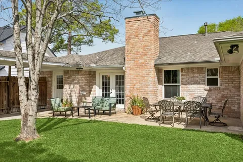 a backyard of a house with table and chairs