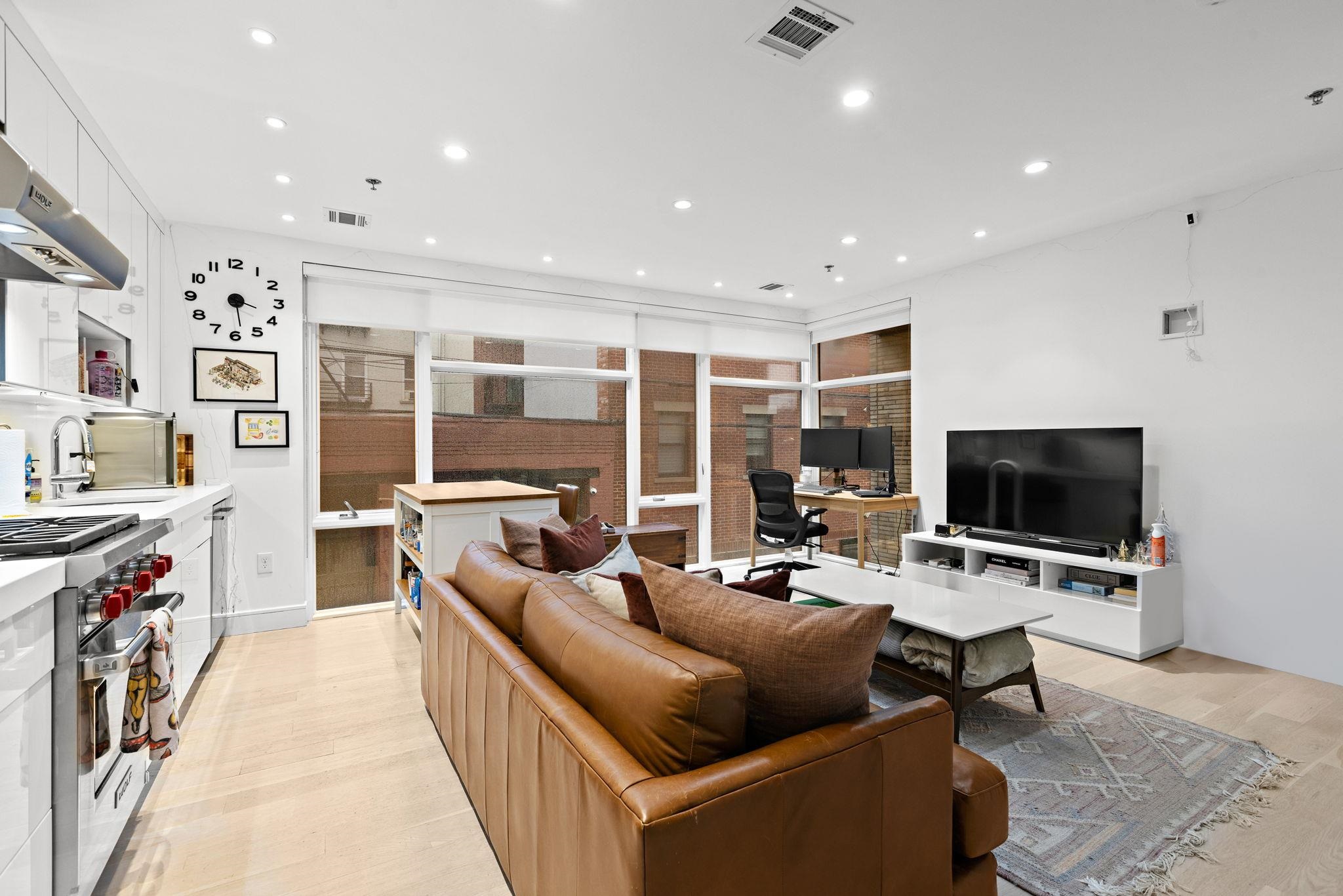 313 Washington Street, Unit 7 Hoboken, NJ 07030 - Photo 2 of 15 a living room with furniture and a flat screen tv