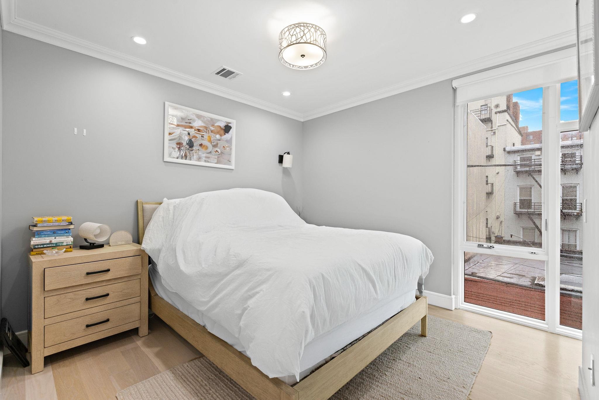 313 Washington Street, Unit 7 Hoboken, NJ 07030 - Photo 9 of 15 a bedroom with a bed and a window