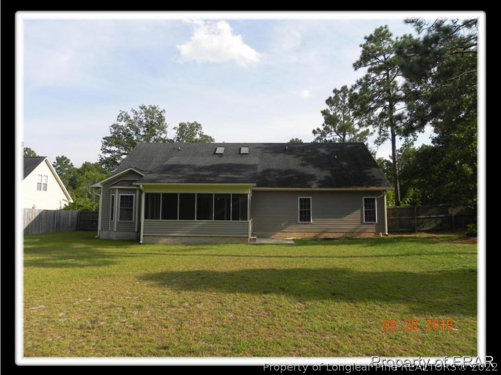 596 East Lake Ridge Road Raeford, NC 28376 - Photo 2 of 25 a front view of a house with a garden and trees