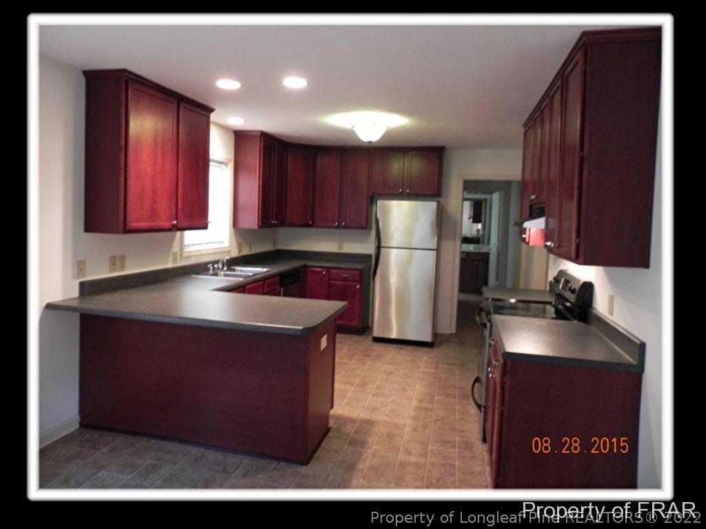 596 East Lake Ridge Road Raeford, NC 28376 - Photo 8 of 25 a kitchen with refrigerator and cabinets
