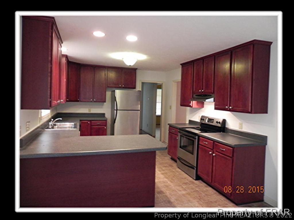 596 East Lake Ridge Road Raeford, NC 28376 - Photo 9 of 25 a kitchen with refrigerator cabinets and wooden floor