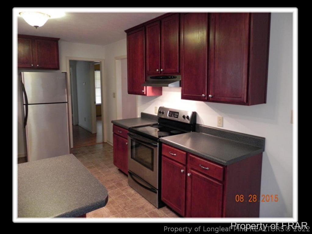 596 East Lake Ridge Road Raeford, NC 28376 - Photo 10 of 25 a kitchen with kitchen island granite countertop wooden cabinets