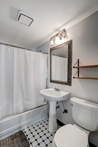 a bathroom with a sink a toilet and mirror
