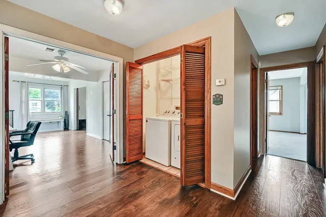 a view of a hallway with wooden floor and a cabinet