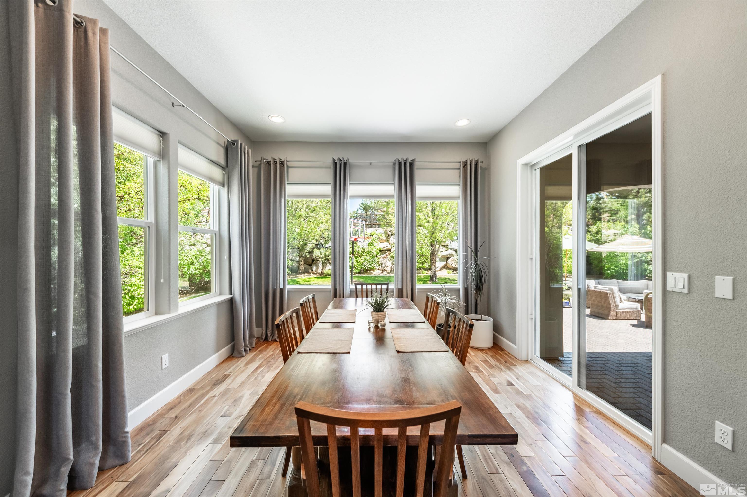 8580 Timaru Trail Reno, NV 89523 - Photo 15 of 40 a view of a dining room with furniture large windows and wooden floor