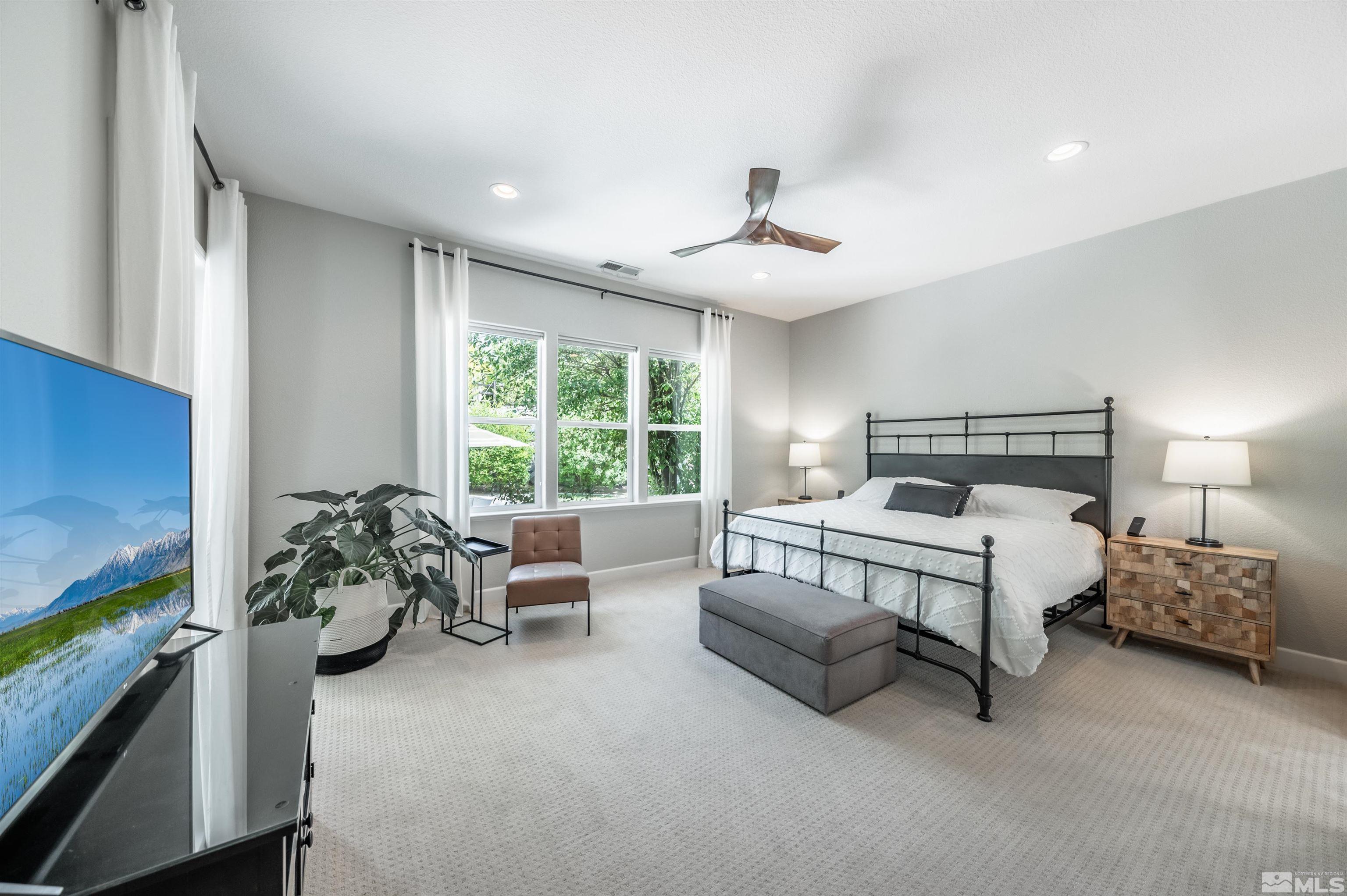 8580 Timaru Trail Reno, NV 89523 - Photo 22 of 40 a spacious bedroom with a bed and a chandelier