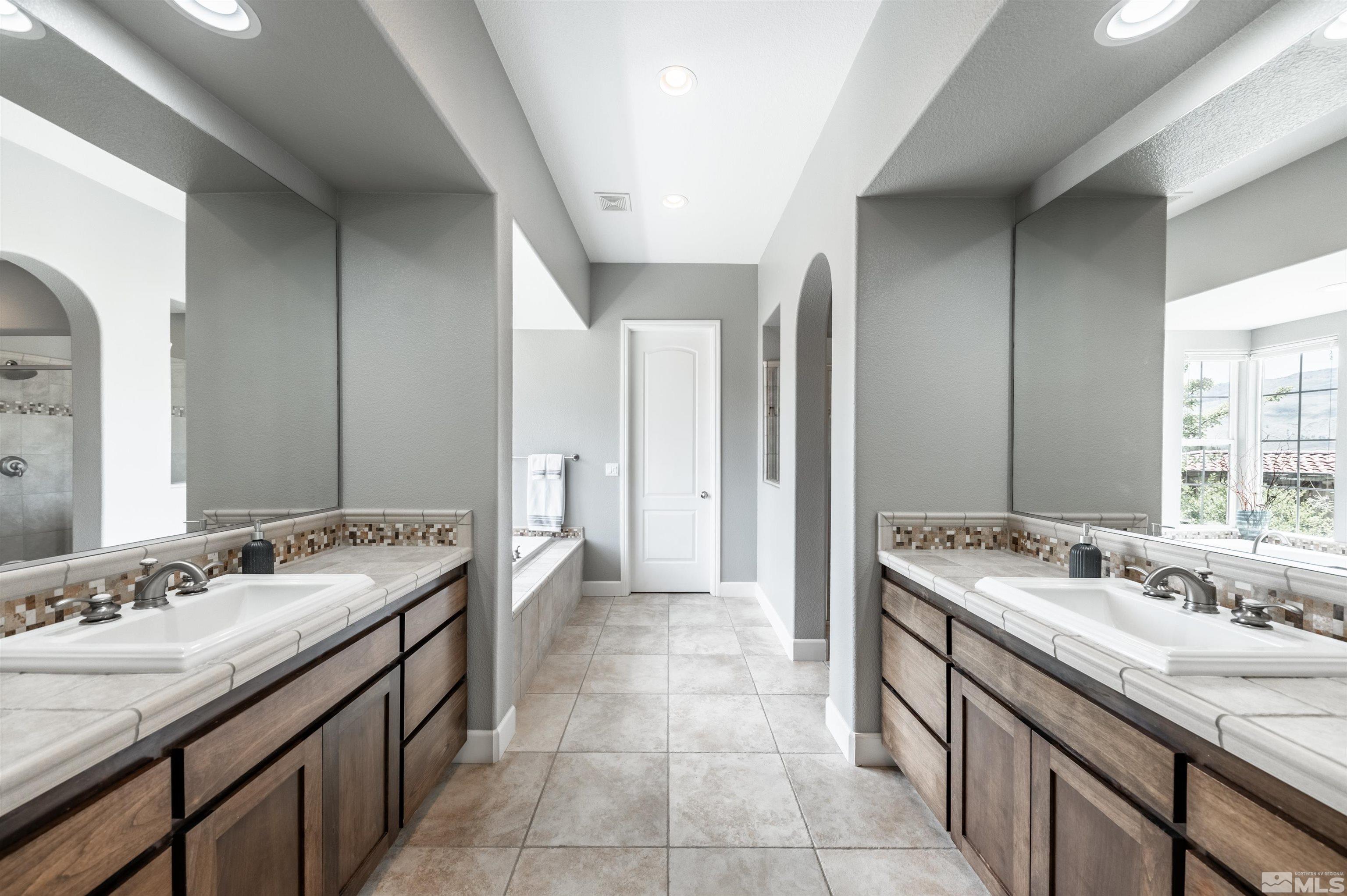 8580 Timaru Trail Reno, NV 89523 - Photo 24 of 40 a spacious bathroom with a granite countertop sink and a mirror