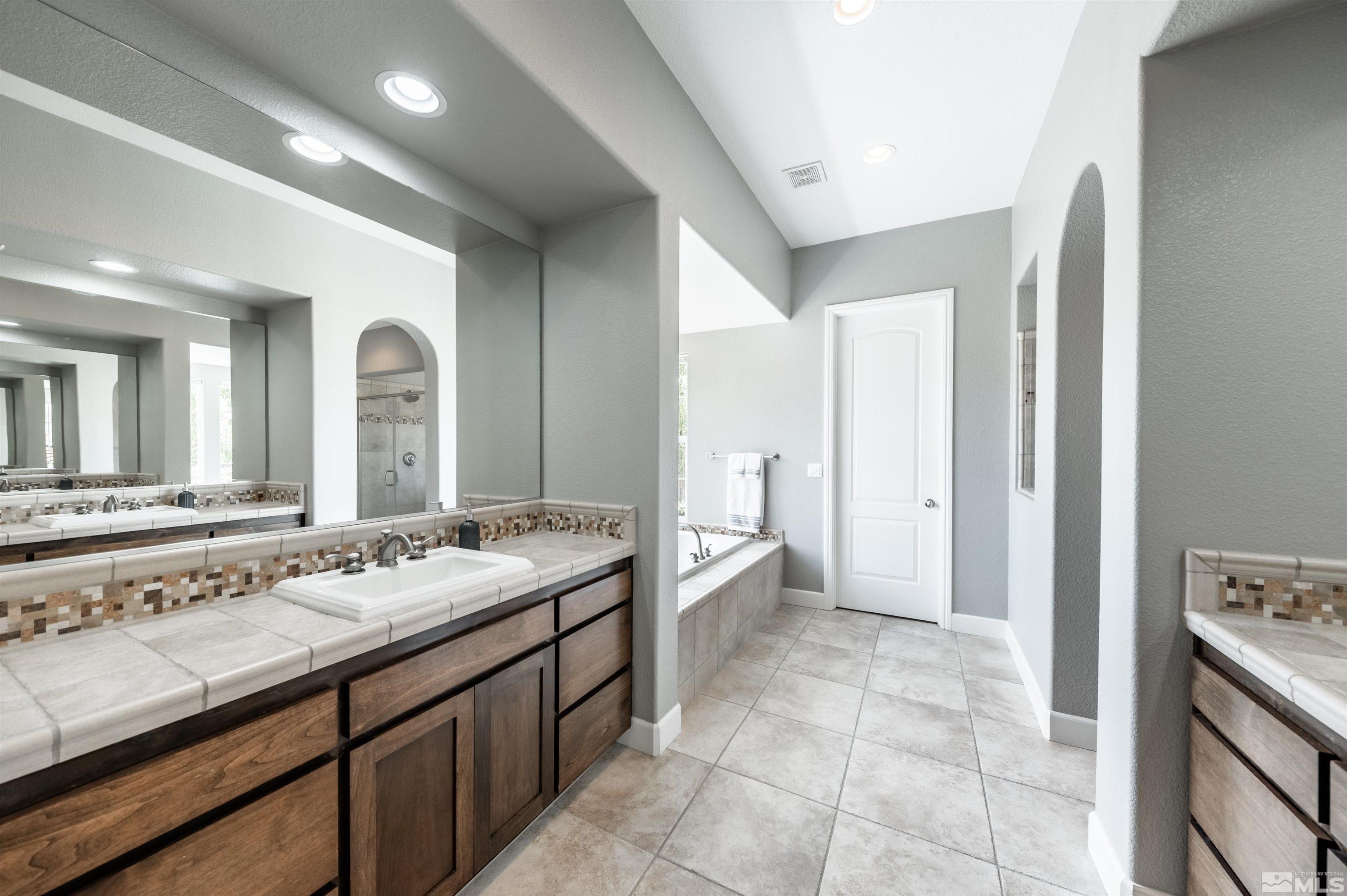 8580 Timaru Trail Reno, NV 89523 - Photo 25 of 40 a spacious bathroom with a granite countertop sink and a mirror