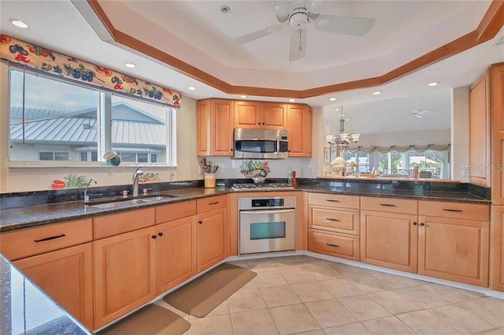 11000 Placida Road, Unit 1003 Placida, FL 33946 - Photo 13 of 41 Kitchen features include a gas range, convection oven/microwave, Miele dishwasher, stainless appliances, granite & views of the marina