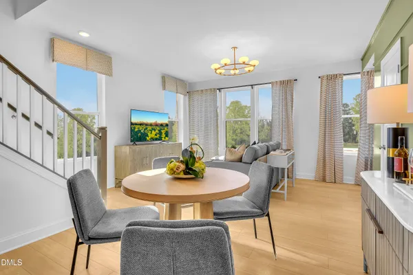 a view of a dining room with furniture a rug and a large window