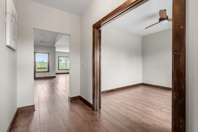 a view of a hallway with wooden floor and a living room