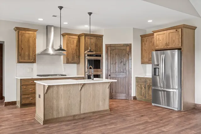 a kitchen with stainless steel appliances a refrigerator and a stove top oven