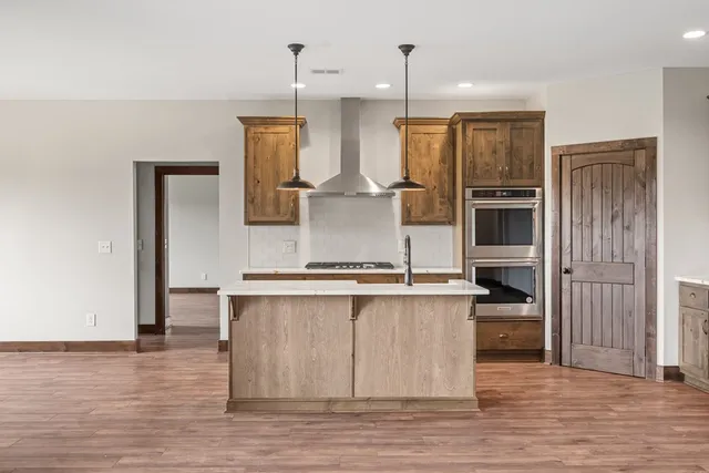 a kitchen with stainless steel appliances granite countertop a sink a stove and a refrigerator
