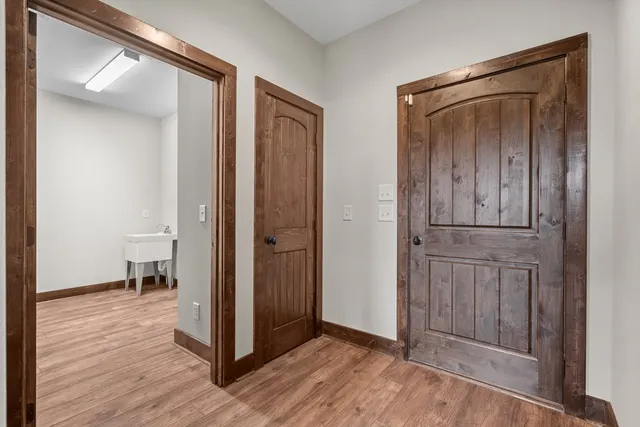 a view of a hallway with wooden floor and closet area