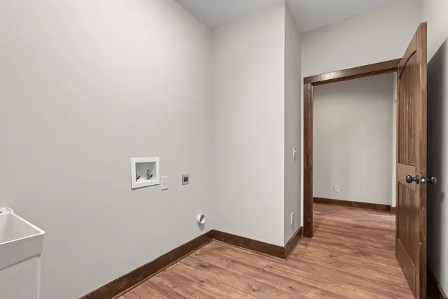 a view of an empty room with wooden floor and closet