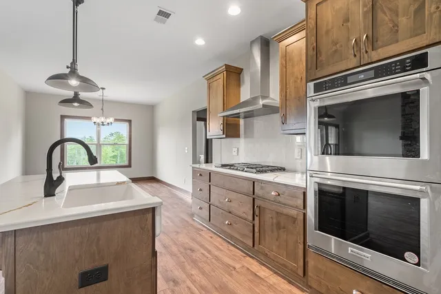 a kitchen with stainless steel appliances a stove sink and cabinets