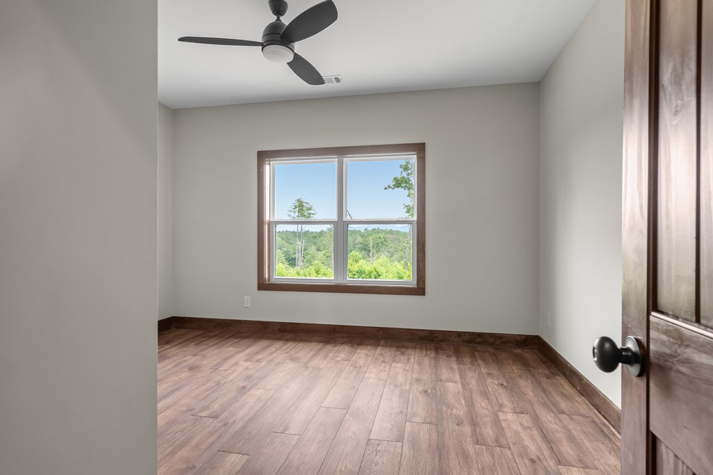 39 Mountaintown Overlook Ellijay, GA 30540 - Photo 36 of 51 an empty room with wooden floor fan and windows