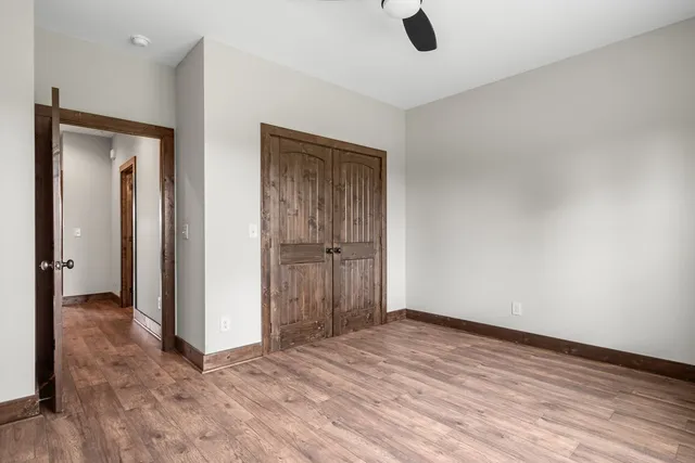 a view of a kitchen with stainless steel appliances granite countertop a stove top oven a refrigerator a sink and a dining table with wooden floor