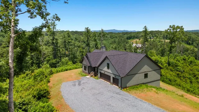 an aerial view of a house next to a yard