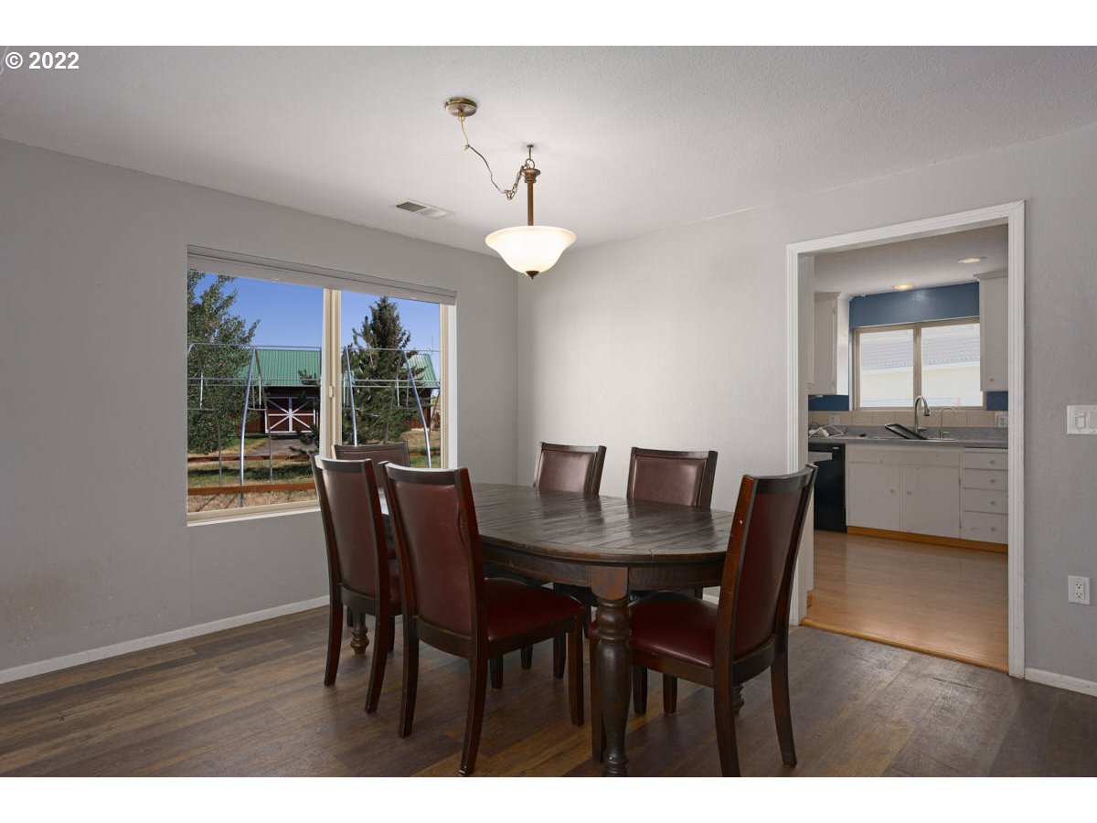 62333 Tucker Down Road Joseph, OR 97846 - Photo 9 of 32 a dining room with wooden floor a chandelier a wooden table and chairs
