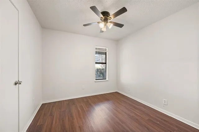 an empty room with a window and a fan