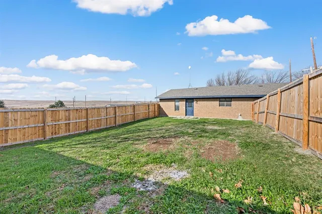 a view of a house with backyard and a garden