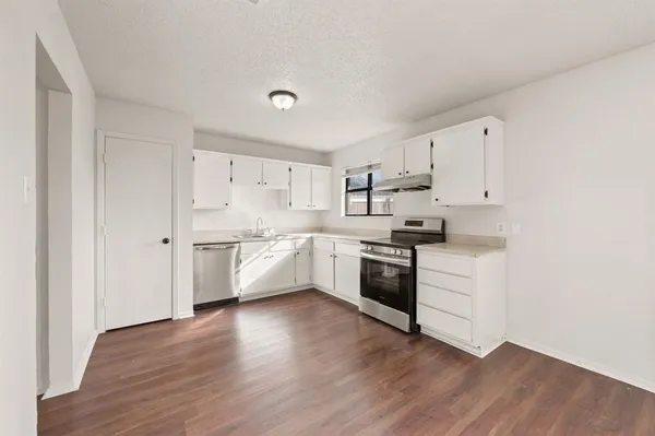 a kitchen with granite countertop white cabinets and white appliances