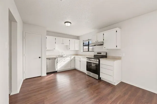 a kitchen with granite countertop white cabinets and white appliances